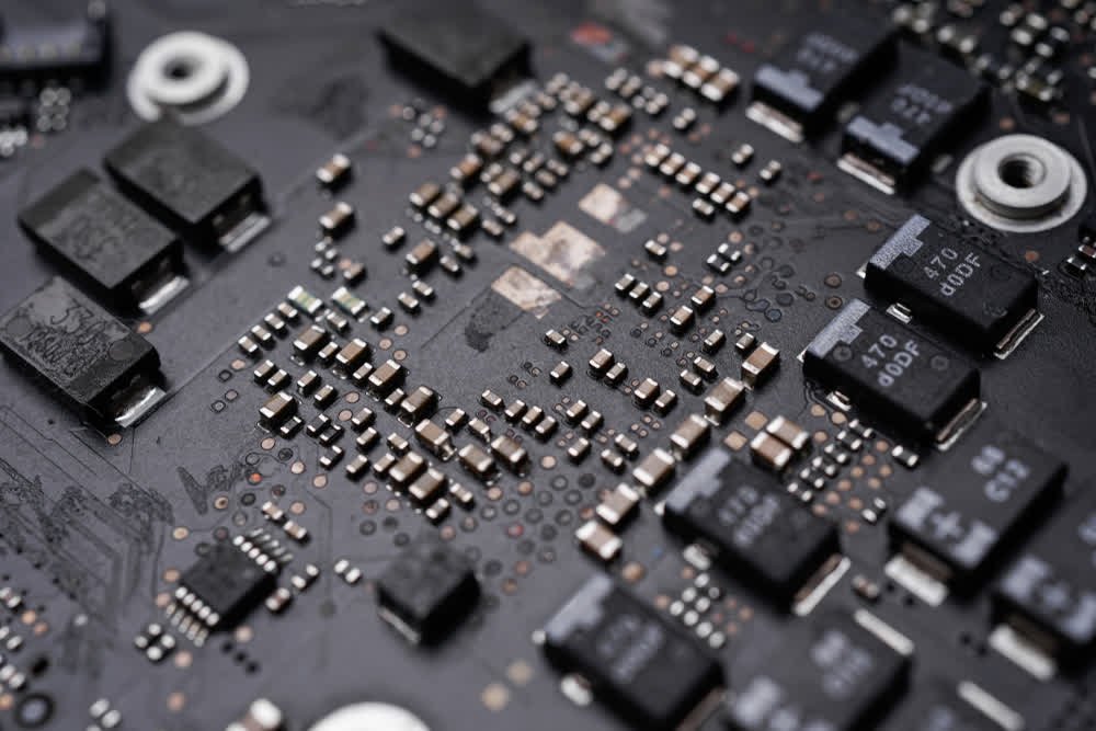 Automated PCB assembly line with robotic arms placing SMD components on circuit boards.